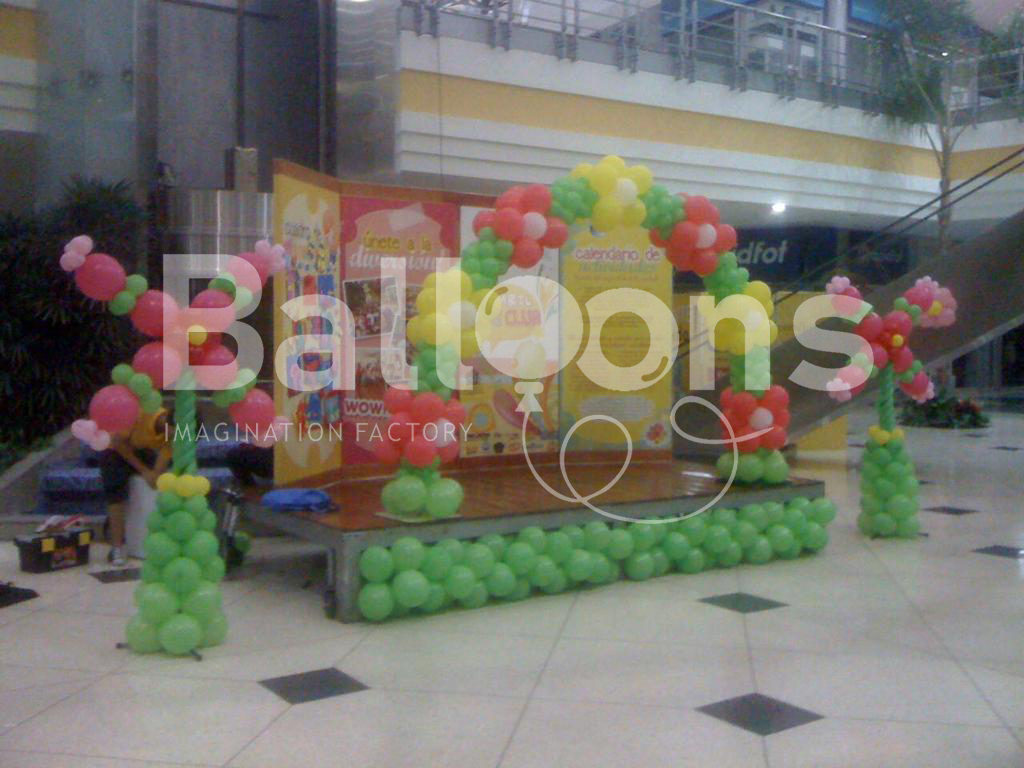 Fachada de globos con forma de arco con flores